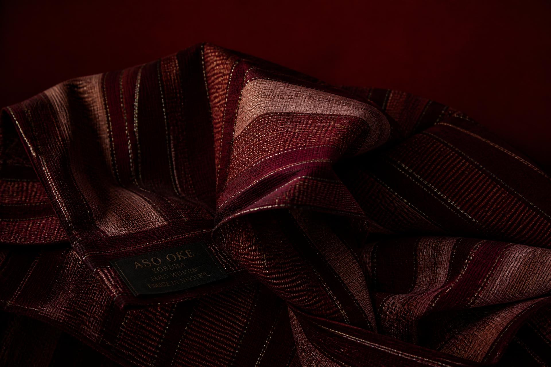 Hand-woven Yoruba aso-oke fabric in deep oxblood tones